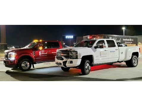 Two trucks, one red and one white, branded with the company logo